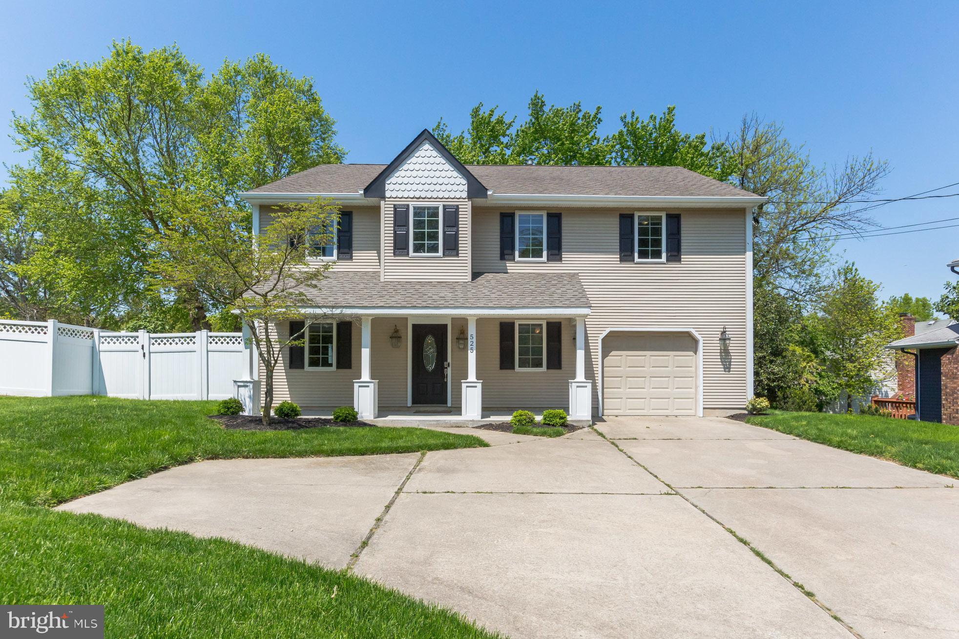 a front view of a house with a garden and trees