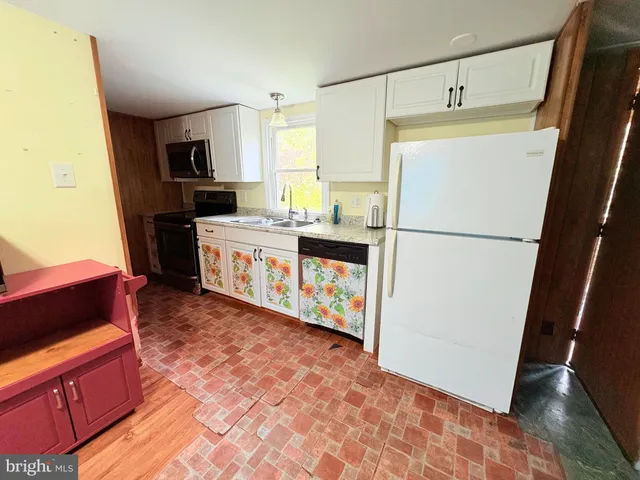 a kitchen with stainless steel appliances granite countertop a refrigerator a stove a sink and a refrigerator