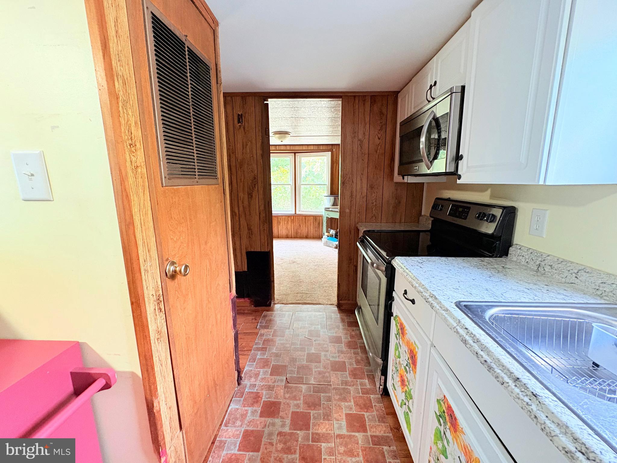 27199 Nevitte Muir Road Westover, MD 21871 - Photo 15 of 31 a kitchen with a sink a stove top oven a refrigerator and a window