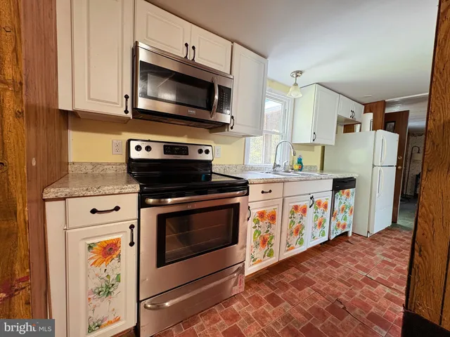 a kitchen with stainless steel appliances granite countertop a stove a microwave and a refrigerator