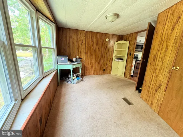 a view of a hallway with furniture and a window