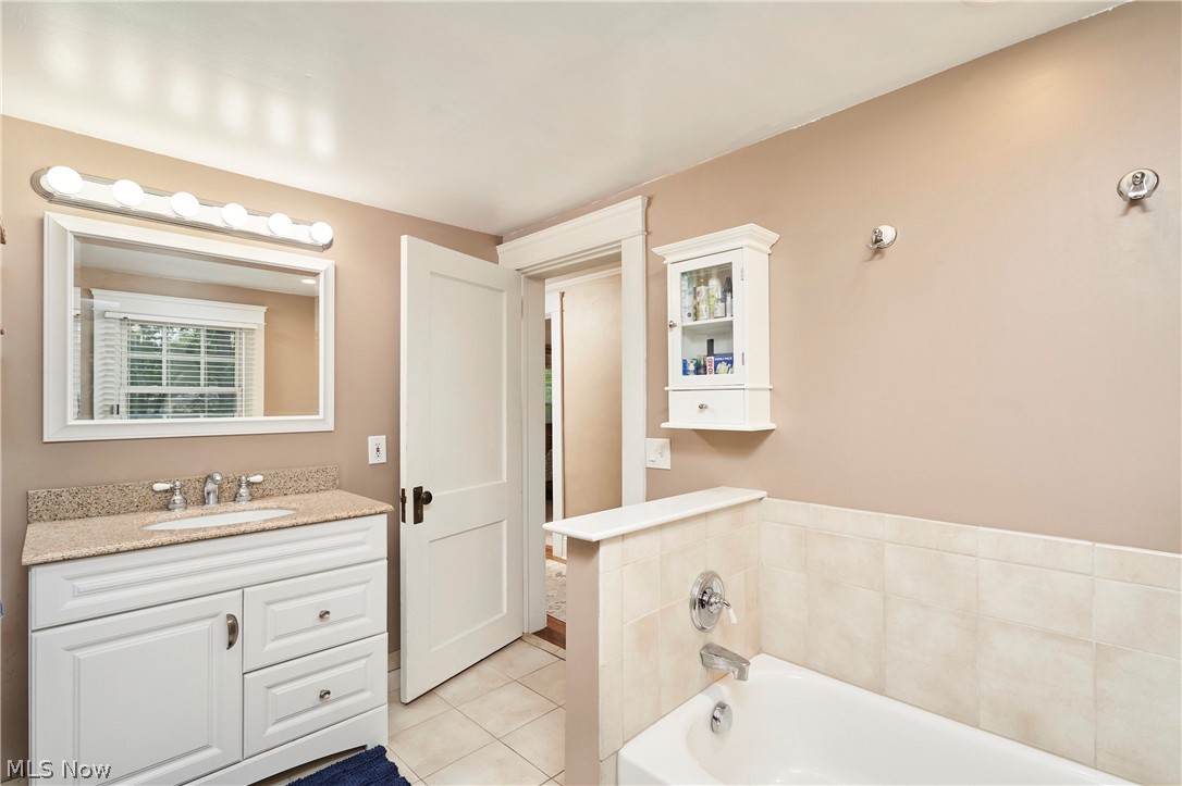 4531 Ardendale Road Cleveland, OH 44121 - Photo 19 of 25 Full bath with vanity, light tile patterned floors, and a garden tub