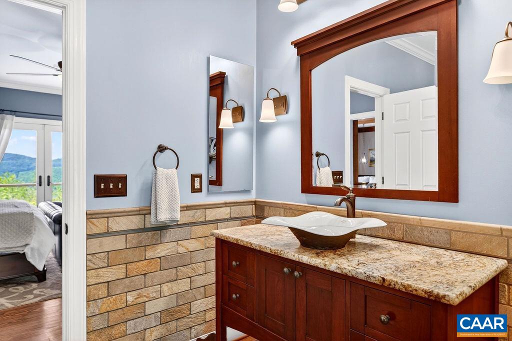 1059 Bryant Mountain Road Roseland, VA 22967 - Photo 24 of 58 a bathroom with a granite countertop sink and a mirror