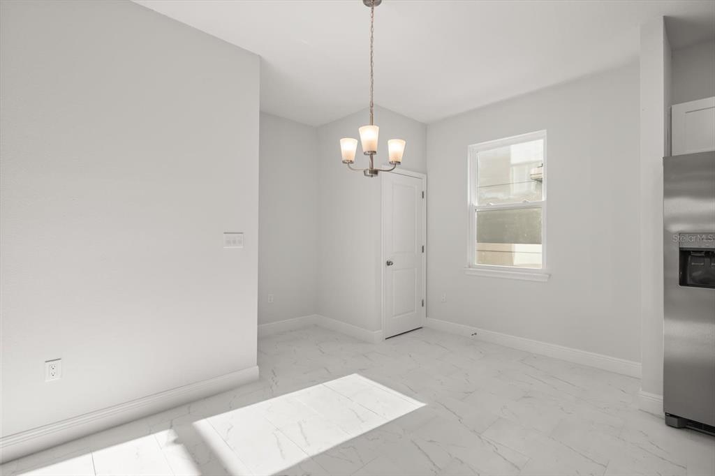 1289 Ash Tree Cove Casselberry, FL 32707 - Photo 11 of 34 en empty room with windows and chandelier