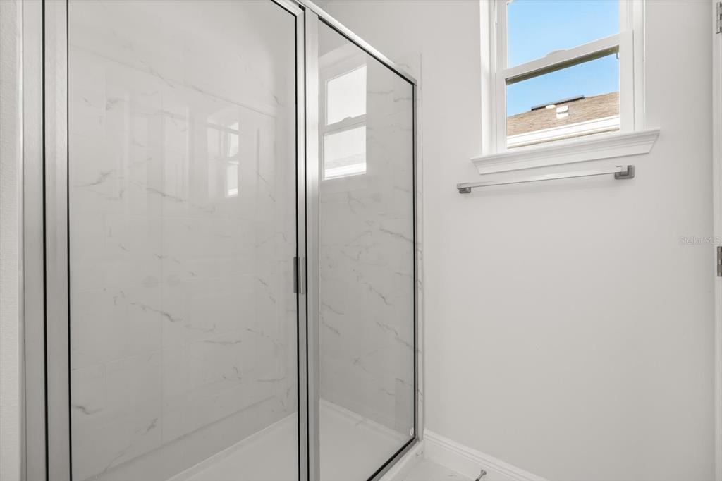 1289 Ash Tree Cove Casselberry, FL 32707 - Photo 19 of 34 a bathroom with a glass shower door