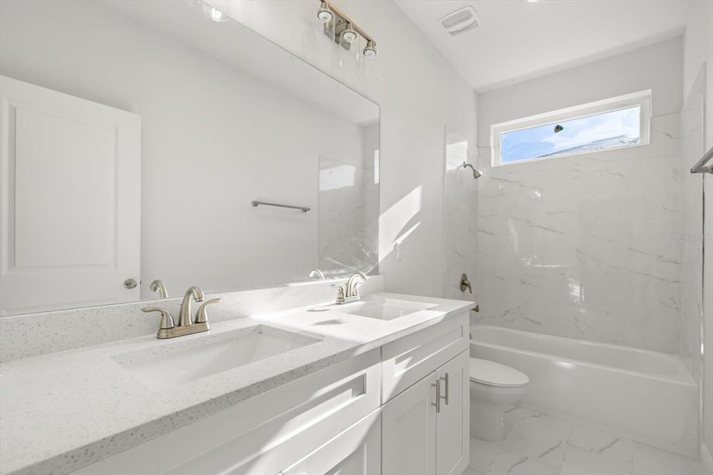 1289 Ash Tree Cove Casselberry, FL 32707 - Photo 22 of 34 a bathroom with a sink a toilet and shower