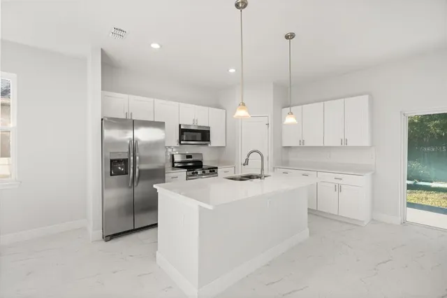 a kitchen with refrigerator cabinets and a sink