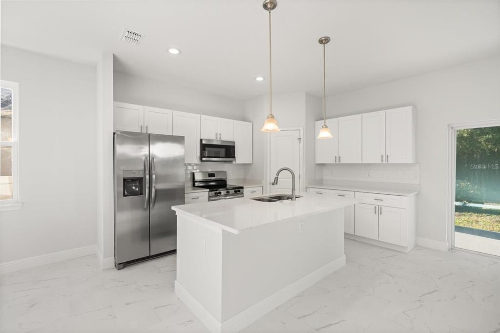 1289 Ash Tree Cove Casselberry, FL 32707 - Photo 4 of 34 a kitchen with refrigerator cabinets and a sink