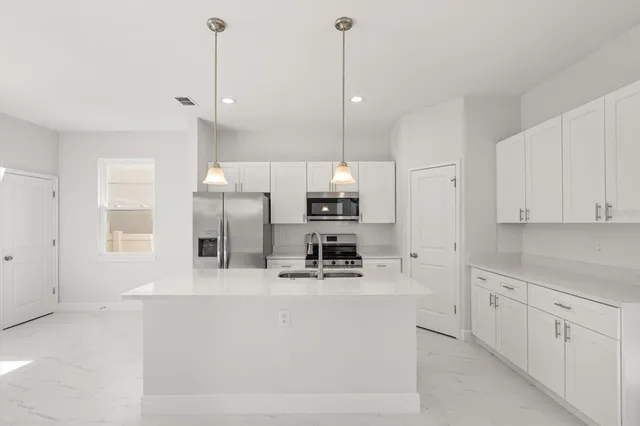a kitchen with kitchen island a sink stainless steel appliances and cabinets