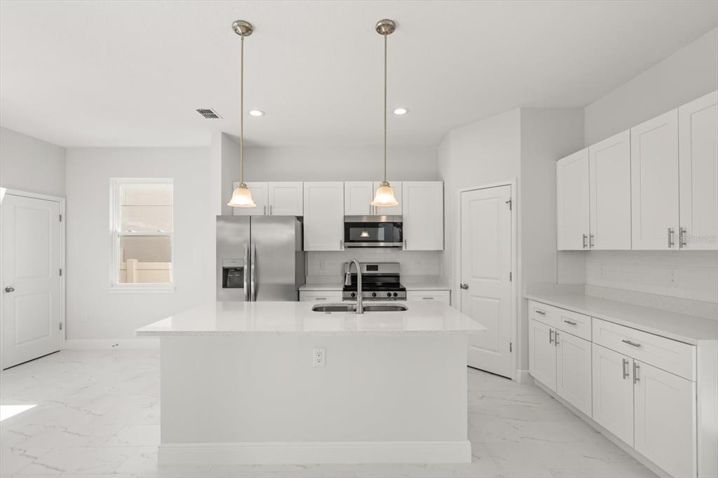 1289 Ash Tree Cove Casselberry, FL 32707 - Photo 5 of 34 a kitchen with kitchen island a sink stainless steel appliances and cabinets