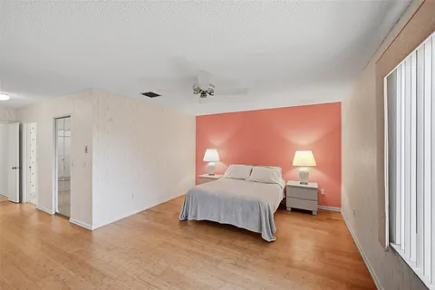 a bedroom with a bed large mirror and a desk