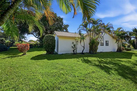 an aerial view of a house with a yard and trees all around