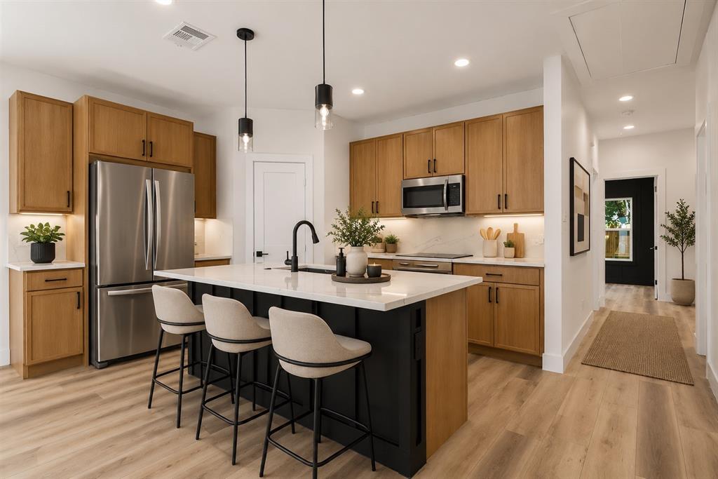 2714 Hector Street Dallas, TX 75210 - Photo 11 of 33 a kitchen with stainless steel appliances granite countertop a sink a stove a refrigerator and a dining table with wooden floor