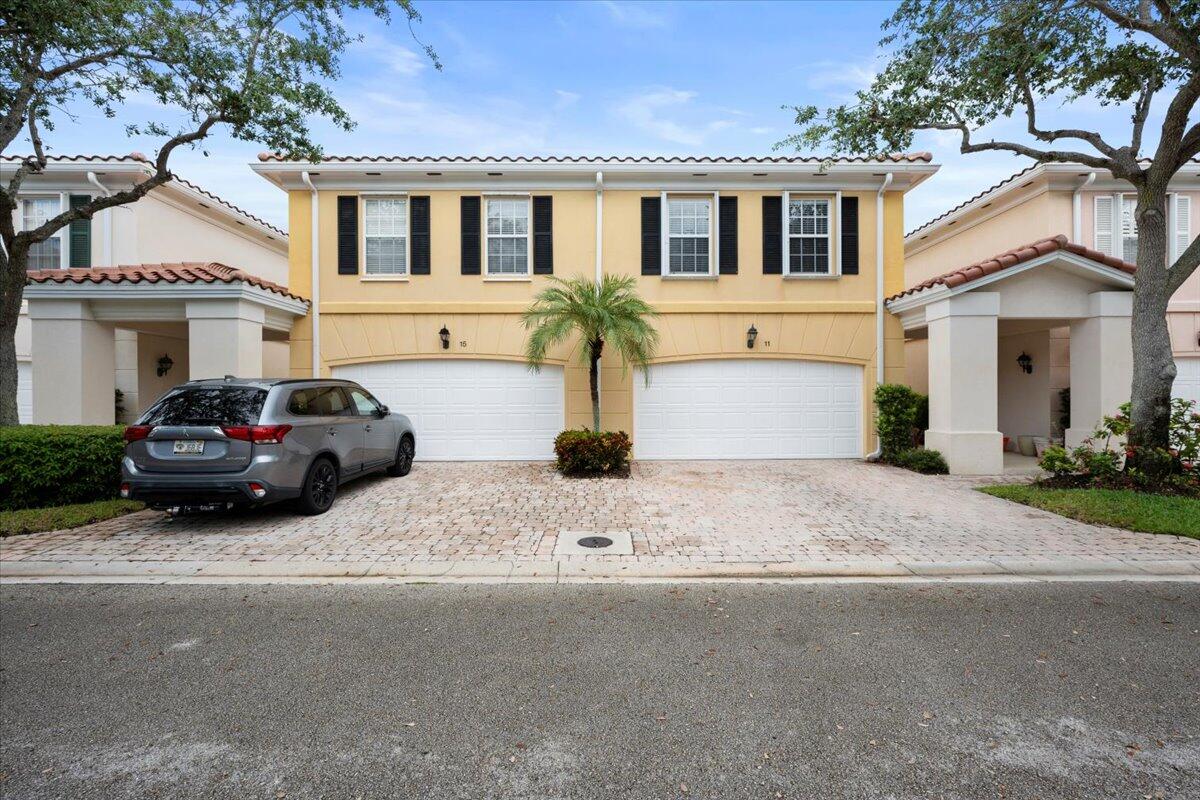 11 Live Oak Circle, Unit 11 Tequesta, FL 33469 - Photo 1 of 27 a front view of a house with a yard and garage