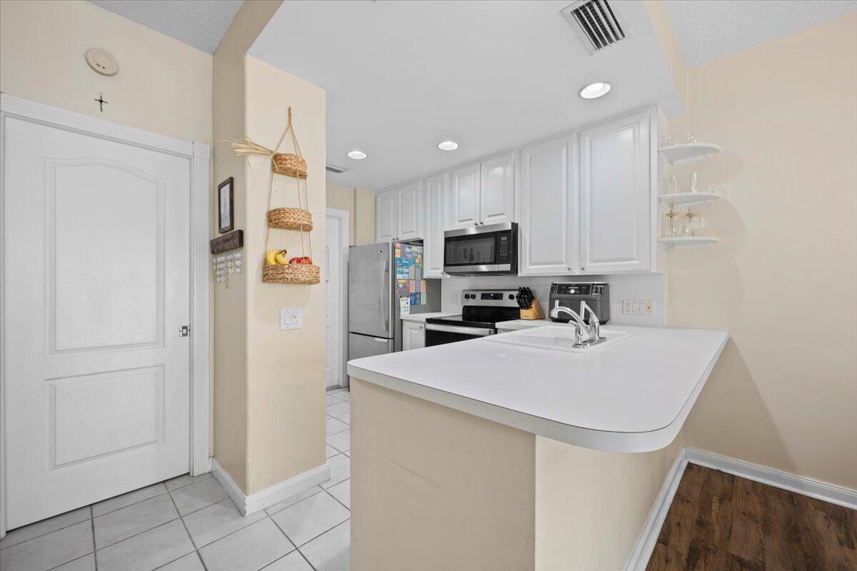 11 Live Oak Circle, Unit 11 Tequesta, FL 33469 - Photo 15 of 27 a kitchen with stainless steel appliances a refrigerator sink and microwave