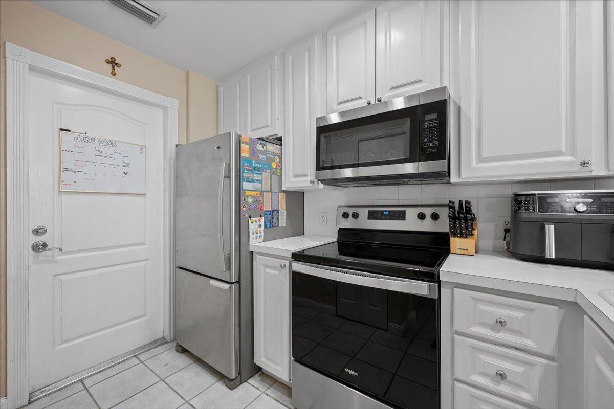 11 Live Oak Circle, Unit 11 Tequesta, FL 33469 - Photo 17 of 27 a kitchen with cabinets and stainless steel appliances