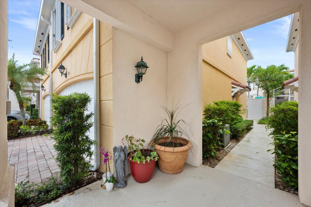 11 Live Oak Circle, Unit 11 Tequesta, FL 33469 - Photo 2 of 27 a view of a backyard with plants and potted plants