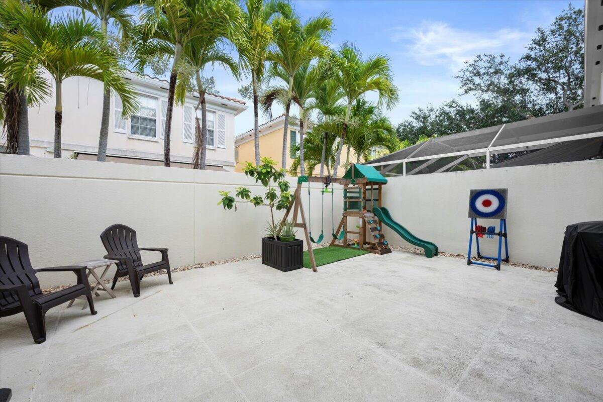 11 Live Oak Circle, Unit 11 Tequesta, FL 33469 - Photo 5 of 27 a view of backyard with a table and chairs