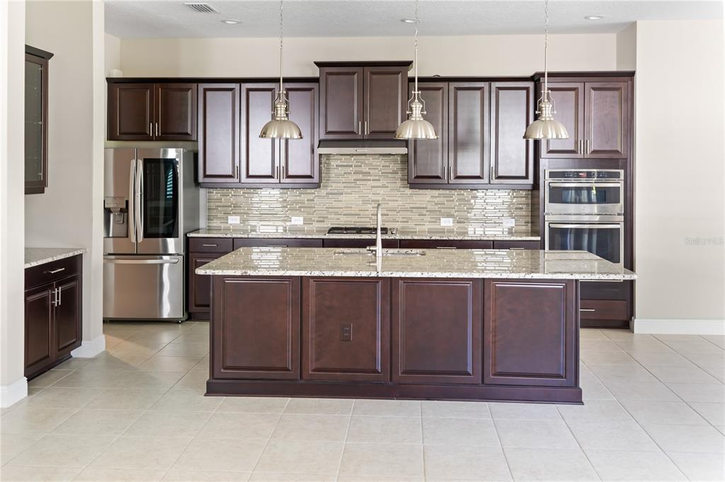 13017 Steinhatchee Loop Venice, FL 34293 - Photo 13 of 98 a kitchen with stainless steel appliances granite countertop a refrigerator and a stove