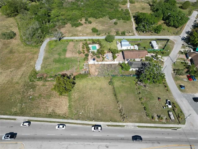 an aerial view of a residential houses with yard