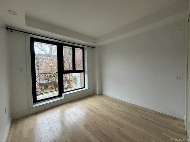 an empty room with wooden floor and large window