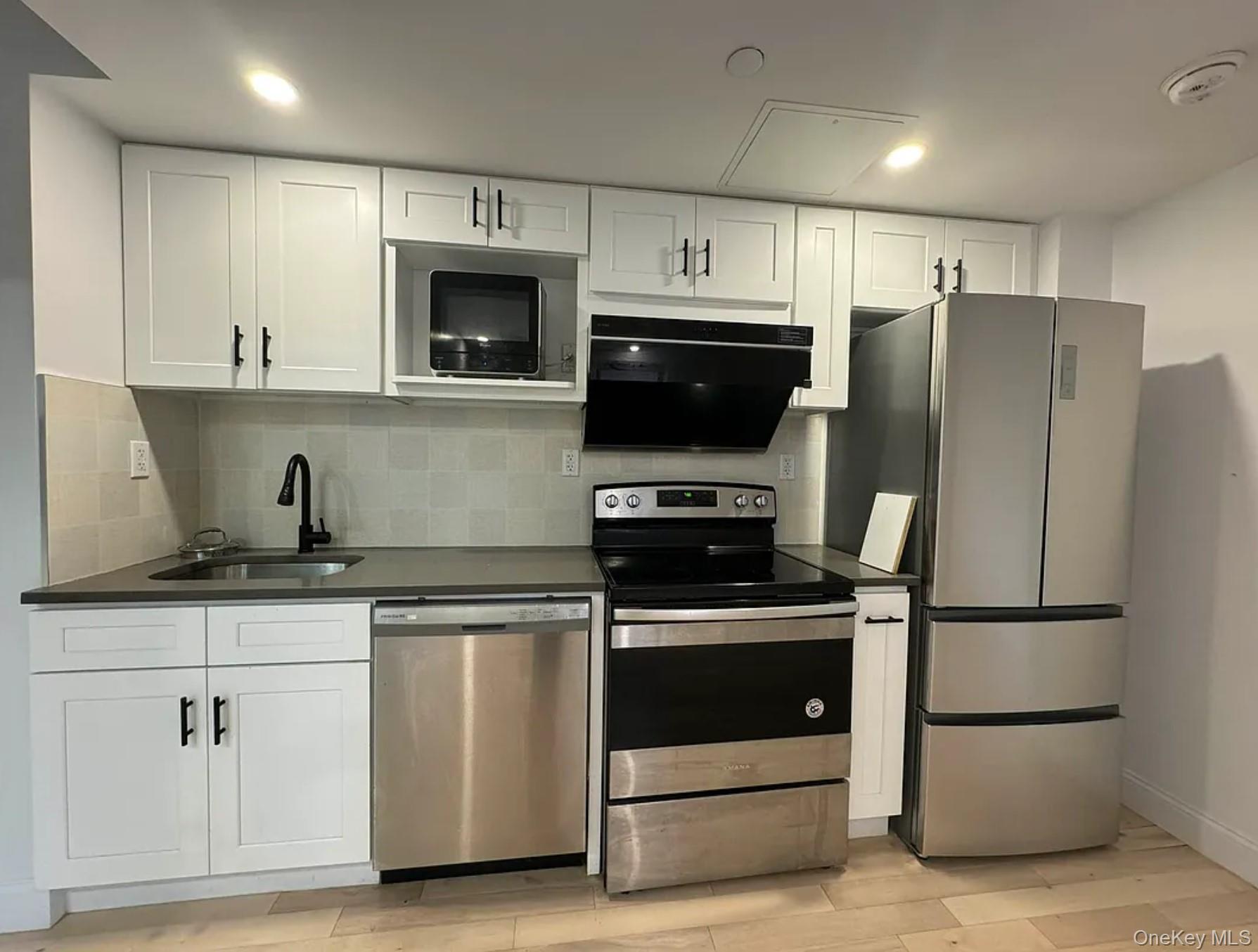 105-25 65th Road, Unit 5C Queens, NY 11375 - Photo 7 of 8 a kitchen with appliances a sink and cabinets