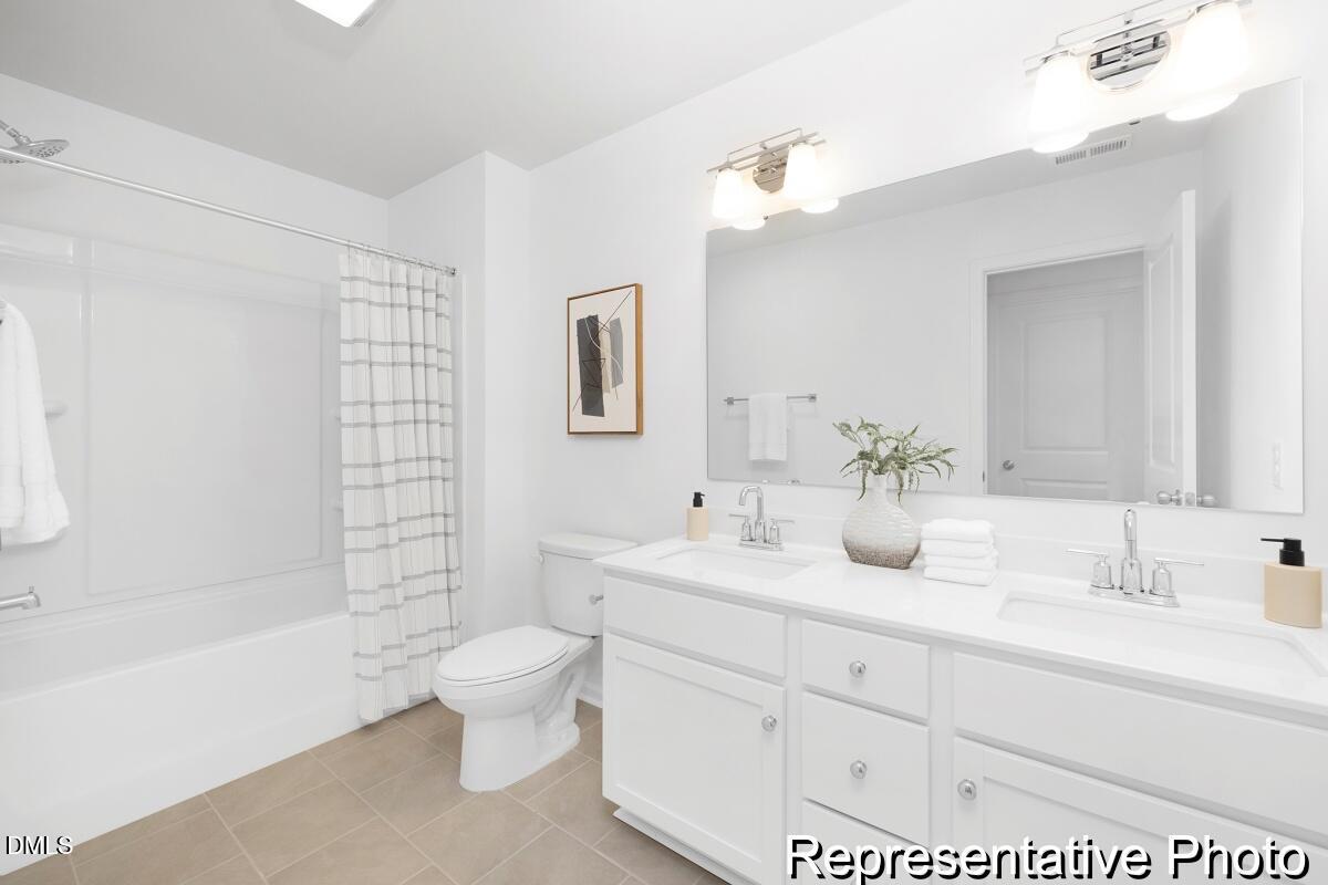 47 Flicker Lane, Unit 188P Angier, NC 27501 - Photo 37 of 38 a bathroom with a double vanity sink toilet mirror and bathtub