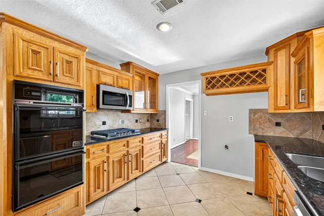 a kitchen with stainless steel appliances granite countertop a stove and a microwave