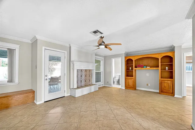 a view of an empty room with a fireplace and a window