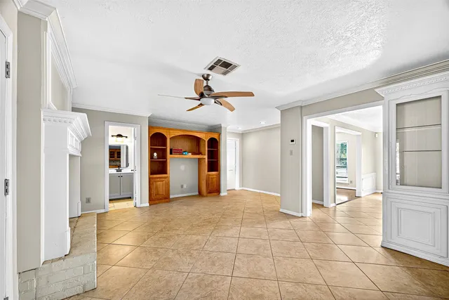 a view of a livingroom with a chandelier fan and windows