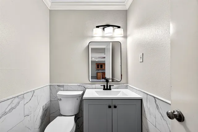 a bathroom with a toilet sink and mirror
