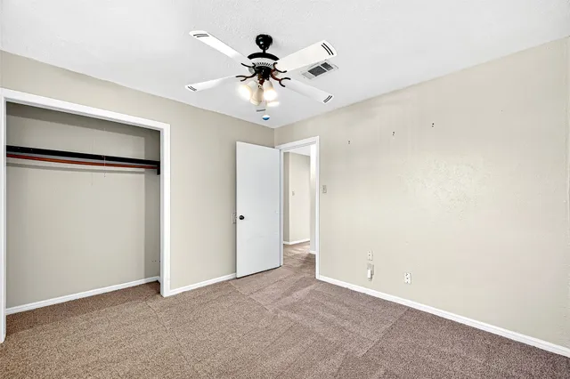 a view of an empty room with a ceiling fan