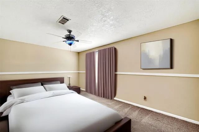 a bedroom with a bed and a ceiling fan