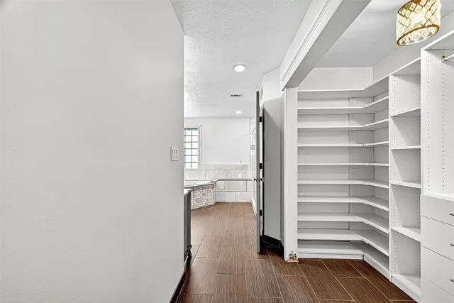 a view of walk in closet with empty racks