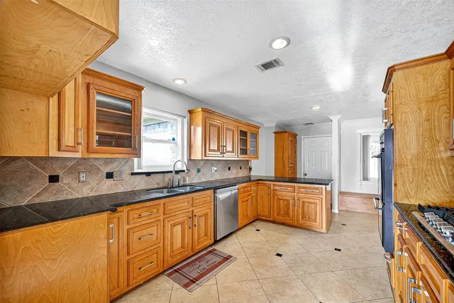 a large kitchen with stainless steel appliances granite countertop a sink and cabinets