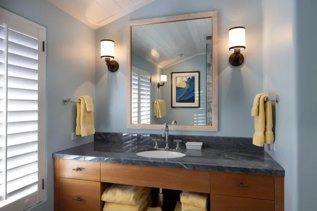 a bathroom with a granite countertop sink and a mirror