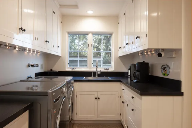 a kitchen with granite countertop a sink a stove and cabinets