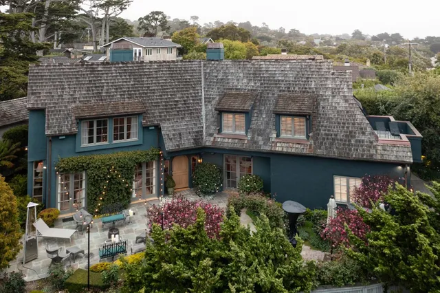 an aerial view of a house with a yard and potted plants