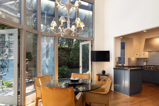 a dining room with furniture and large windows