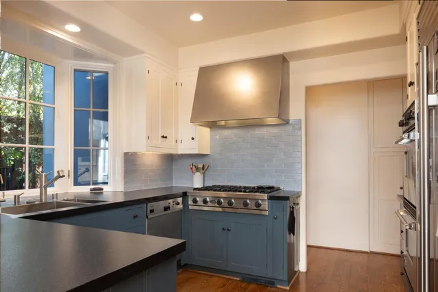 a kitchen with stainless steel appliances a sink stove and a refrigerator