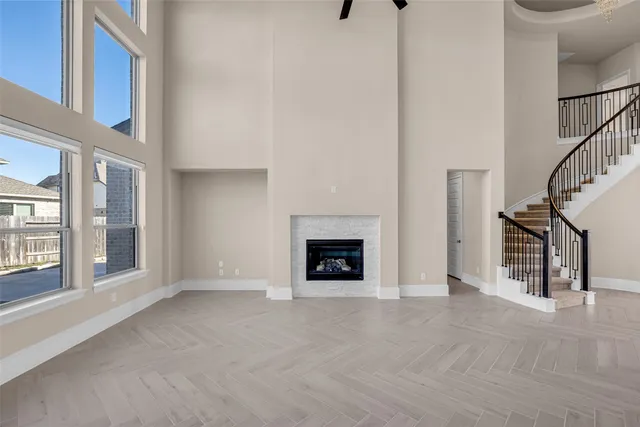 a view of an empty room with fireplace and a window