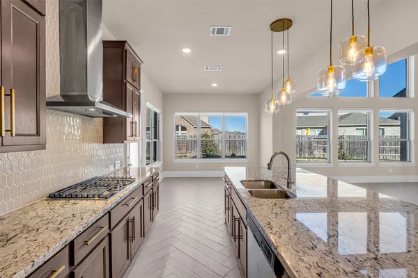 a kitchen with stainless steel appliances granite countertop a sink counter space and a stove top oven