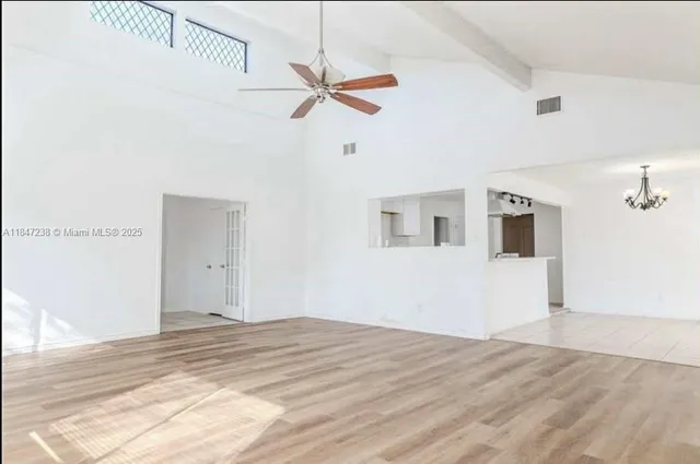 a view of a livingroom with wooden floor and a ceiling fan