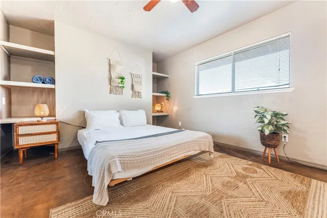 a bedroom with a bed and a potted plant