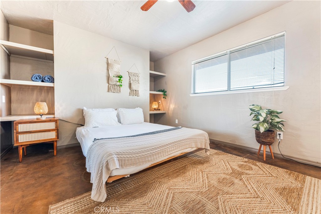 7071 Rubidoux Avenue Yucca Valley, CA 92284 - Photo 11 of 50 a bedroom with a bed and a potted plant