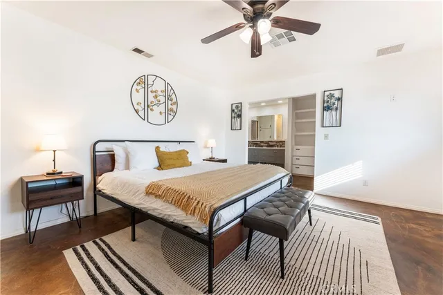 a bedroom with a bed and a table with wooden floor