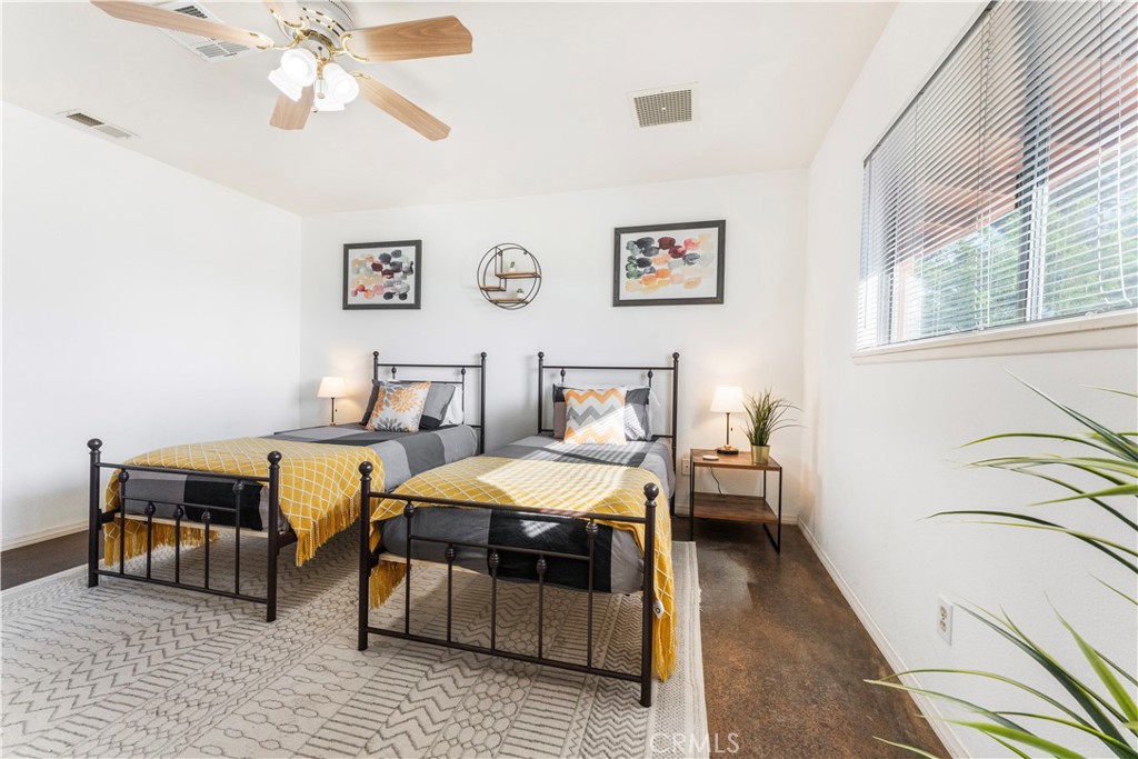 7071 Rubidoux Avenue Yucca Valley, CA 92284 - Photo 15 of 50 a bedroom with a bed and a chandelier