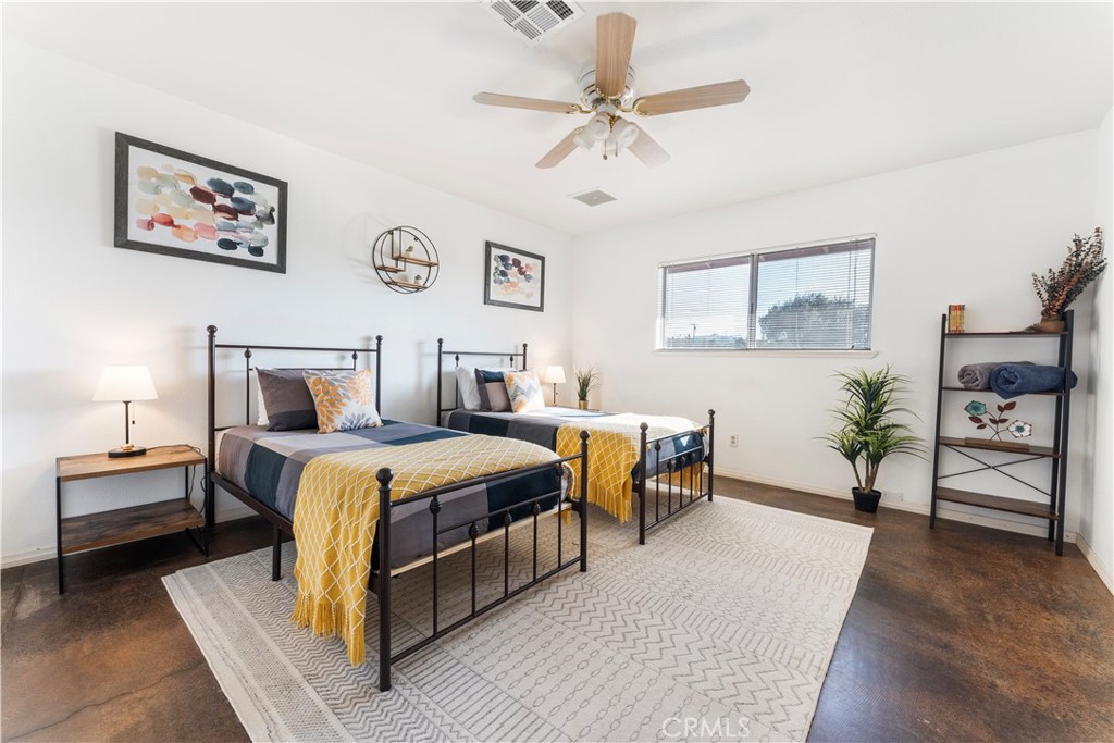 7071 Rubidoux Avenue Yucca Valley, CA 92284 - Photo 16 of 50 a bedroom with furniture and a chandelier