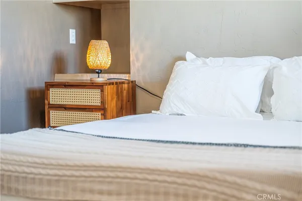 a bedroom with a bed and painting on the wall