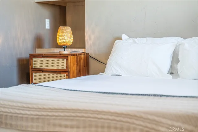 a bedroom with a bed and painting on the wall